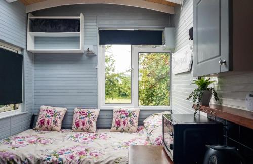 ein kleines Zimmer mit einem Bett in einem winzigen Haus in der Unterkunft Shepherds hut Bath in Wick