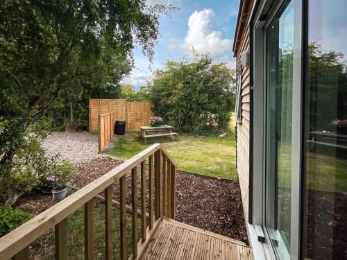 a balcony with a view of a yard with a picnic table at Shepherds hut Bath in Wick