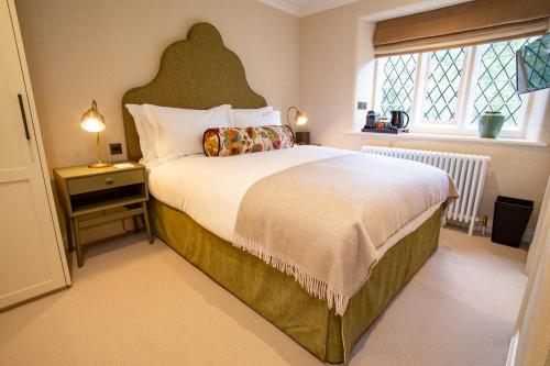 a bedroom with a large bed and a large window at The Falcon Hotel in Northampton