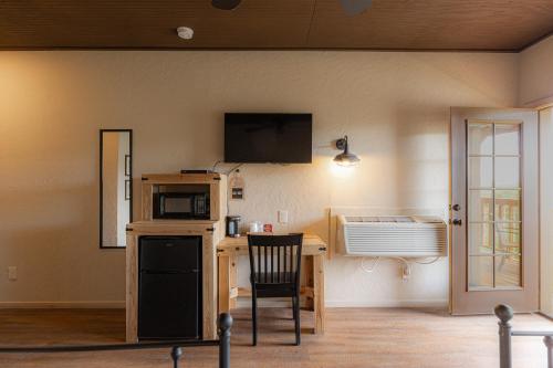 een kamer met een keuken met een bureau en een magnetron bij -Pet Friendly- Miners Cabin #5 -Two Double Beds - Private Balcony in Tombstone