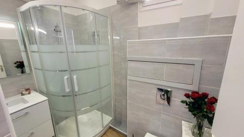 La salle de bains est pourvue d'une douche en verre et de roses rouges. dans l'établissement Ze Perfect Place - Confortable appartement 2 CHB - Asc - Port - Garibaldi, à Nice