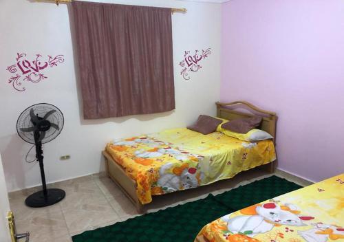 een slaapkamer met 2 bedden en een ventilator bij AC, Wi-Fi Shahrazad Beach Apartment-2 in Alexandrië