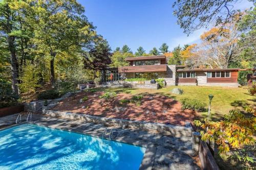a house with a swimming pool in the yard at Peaceful Getaway Cottage on grounds of historic mid-century gem in Northborough