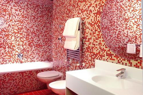 ein Badezimmer mit einem Waschbecken, einem WC und einem Spiegel in der Unterkunft Hotel Abitart in Rom