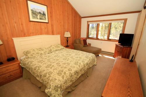 a bedroom with a bed and a chair and a window at Mountainback #97, Loft in Mammoth Lakes
