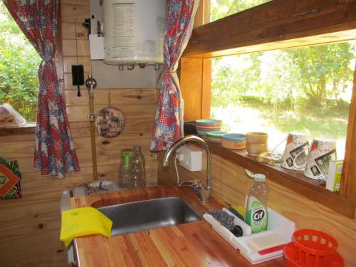 cocina con fregadero y ventana en Hospedaje Las Gardenias en Lago Puelo