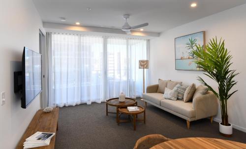 a living room with a couch and a table at X Kirra Apartments in Gold Coast