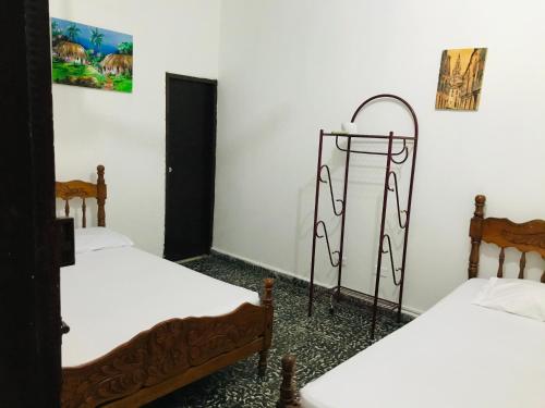 two beds in a room with white walls at Hotel Costa Norte in Santa Marta
