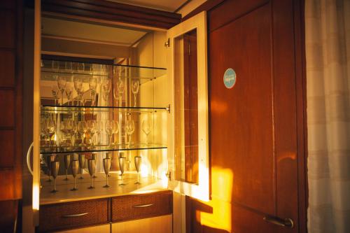 a glass cabinet with many glasses in it at Apto Panorâmico 3 quadras da Rua Coberta in Gramado