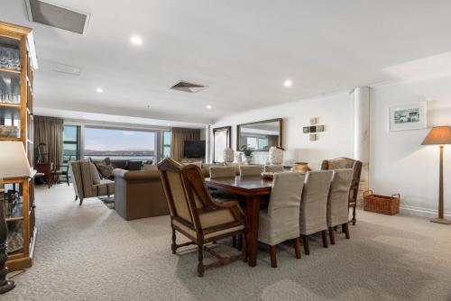 a living room with a dining room table and chairs at Auckland Waterfront Serviced Apartments on Prince's Wharf in Auckland