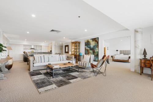 a living room with a couch and a table at Auckland Waterfront Serviced Apartments on Prince's Wharf in Auckland
