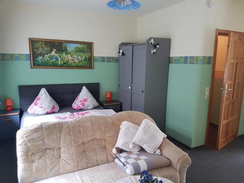 a bedroom with a bed and a couch at Landpension Zum Schweizerberg in Neugrimnitz