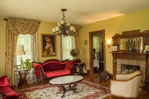 a living room with a red couch and a fireplace at The Ann Stevens House in Cassadaga