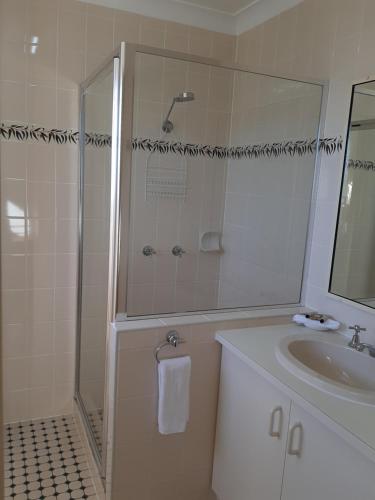 a bathroom with a shower and a sink at Country Rose Motel Warwick in Warwick