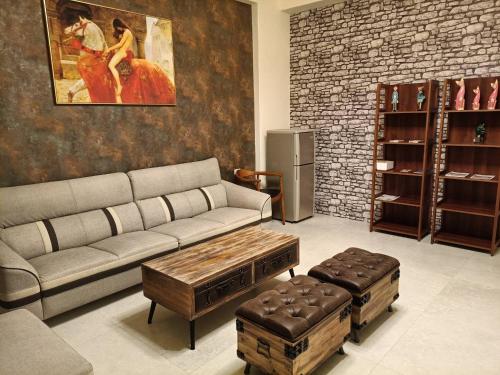 a living room with a couch and two ottomans at Here Homestay Guoguang Branch in Ruisui