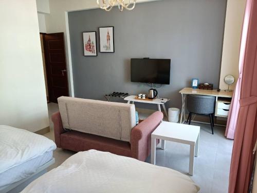 a living room with a couch and a tv at Heye Homestay Guoguang Branch A2571 B2572 in Ruisui