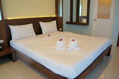 two pillows shaped like birds are sitting on a bed at Chanpraya Resort in Chanthaburi