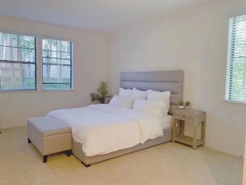a white bedroom with a large bed and two windows at Irvine 2Bedroom 2 Bathroom Apartment with Kitchen Pool gym in Irvine
