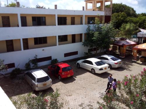 a group of cars parked in front of a building at Armaan Guest House in Diani Beach
