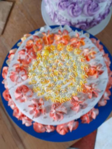 a cake on a plate with flowers on a table at Jojies Homestay Fortkochi in Cochin