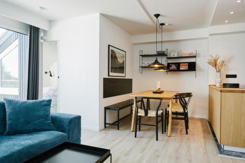 a living room with a table and a blue couch at Welcome in - Ferienwohnung 'Buena Vista' mit Dachterrasse und Abstellraum, in der Nähe der Pisten in Winterberg