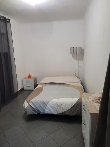 une chambre avec un lit dans une pièce blanche dans l'établissement Appartement Moulinet, à Moulinet
