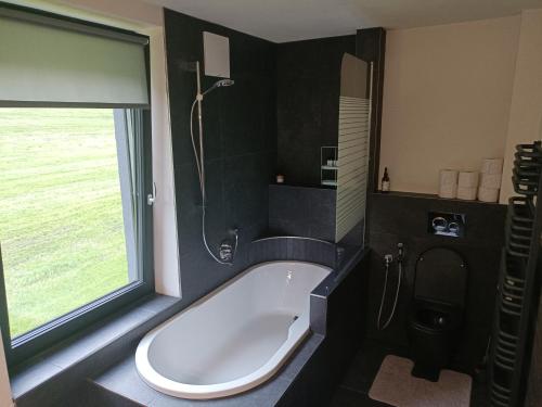 eine Badewanne im Bad mit Fenster in der Unterkunft ALPartment 38 in Rauris