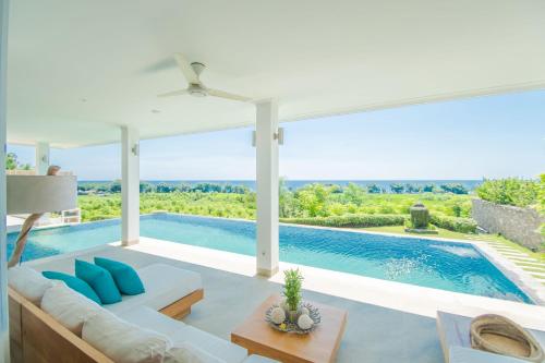 a living room with a couch and a swimming pool at Deep Blue Villa Bali in Umeanyar