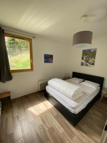 une chambre avec un lit et une fenêtre dans l'établissement Foux d Allos Centre de la Station 4 Pièces 8 Personnes, à Allos