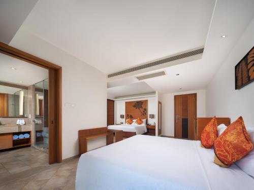 a bedroom with a white bed and a bathroom at Mangrove Tree Resort World Sanya Bay-Kapok in Sanya