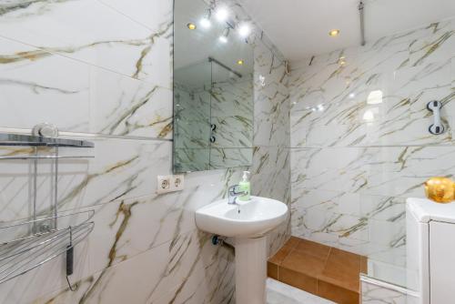 a white bathroom with a sink and a mirror at Apartment Fuengirola City Station in Fuengirola