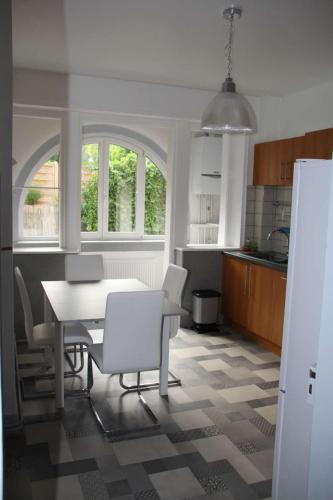 une cuisine avec une table et des chaises dans une cuisine dans l'établissement Appartement T3 très calme - Le Bartholdi - Centre de Colmar, à Colmar
