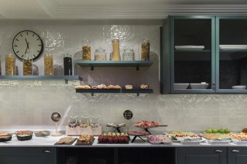 cocina con barra con comida y reloj en Petit Palace Puerta de Triana, en Sevilla