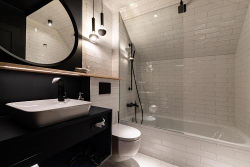 a bathroom with a sink and a toilet and a tub at Hotel / Weingut Meintzinger in Frickenhausen