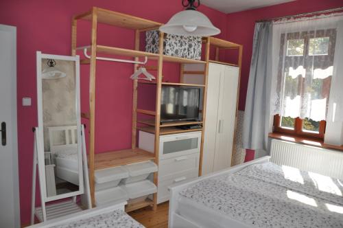 a bedroom with pink walls and a bunk bed at Apartmán u Václava v centru města in Litomyšl