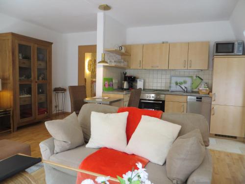 a living room with a couch with red and white pillows at Weisses-Haus-am-Kurpark-Fewo-Bergblick in Bad Suderode