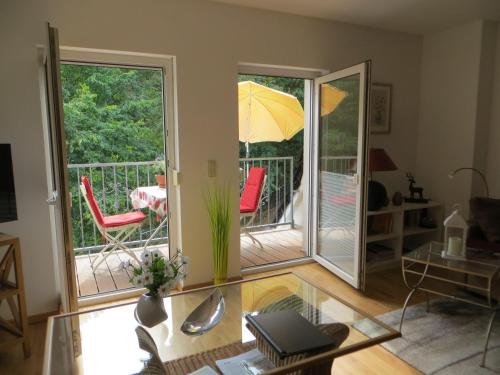 a living room with a balcony with an umbrella at Weisses-Haus-am-Kurpark-Fewo-Bergblick in Bad Suderode