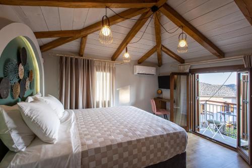 sypialnia z łóżkiem w pokoju z balkonem w obiekcie Samis Pelion LuxuryLiving w mieście Portariá