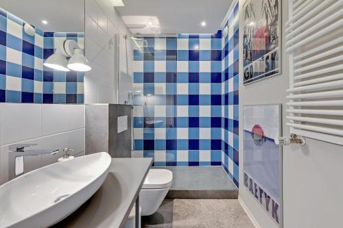 a bathroom with a tub and a toilet and a sink at Grand Apartments - Tartaczna Sailor Studio Gdańsk in Gdańsk
