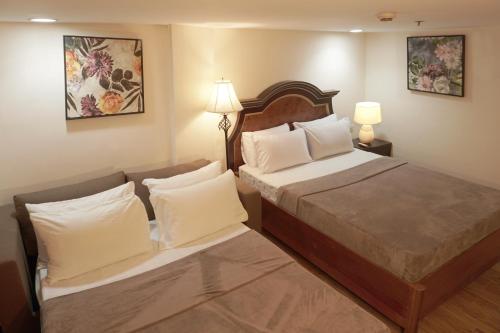 a hotel room with two beds and two lamps at 1775 Adriatico Suites in Manila