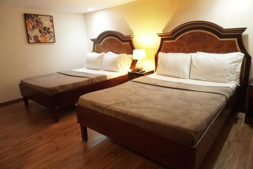 a hotel room with two beds and two lamps at 1775 Adriatico Suites in Manila