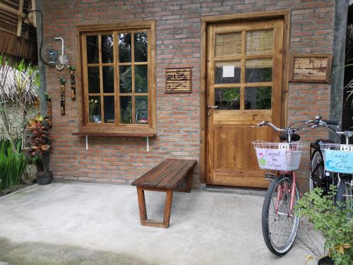 a bike parked in front of a building with a bench at Coconut Tree Cottages in Batukaras