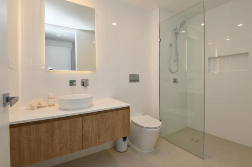 a bathroom with a toilet and a sink and a shower at X Kirra Apartments in Gold Coast