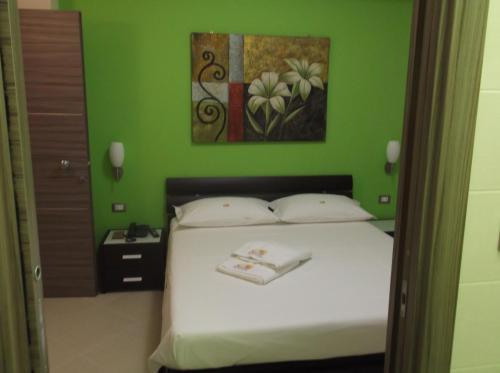 sypialnia z łóżkiem i zieloną ścianą w obiekcie Suliccenti b&b Marzamemi w mieście Marzamemi