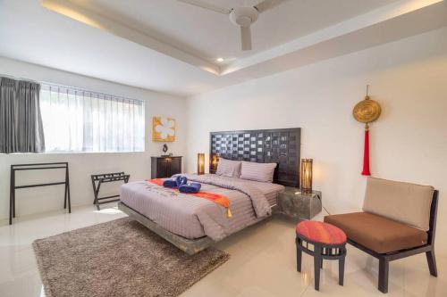 sypialnia z dużym łóżkiem i krzesłem w obiekcie Studio Iris w mieście Chaweng