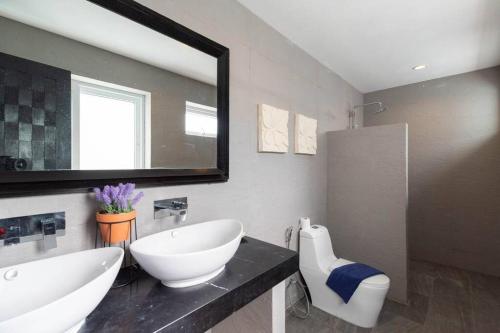 łazienka z umywalką i dużym lustrem w obiekcie Studio Iris w mieście Chaweng