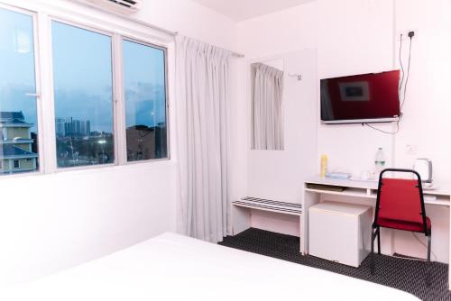 a white room with a desk and a window at Ridel Sunset Hotel in Kota Bharu