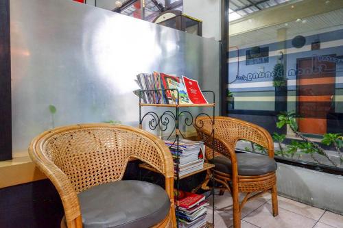 two wicker chairs and a table with books at RedDoorz Syariah @ Sunan Bonang Magelang in Magelang