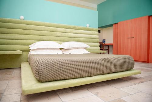 a bed in a room with a green wall at Monteforte Resort in Ugento