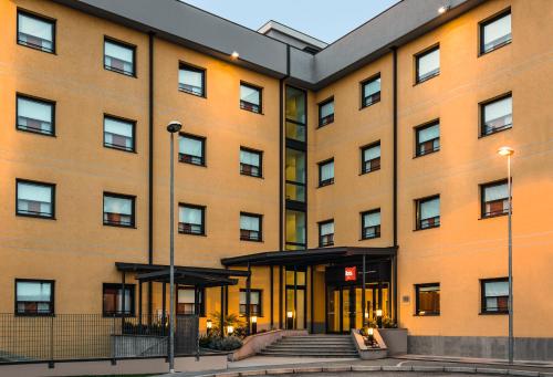 an apartment building with a staircase in front of it at Hotel Ibis Milano Malpensa in Cardano al Campo